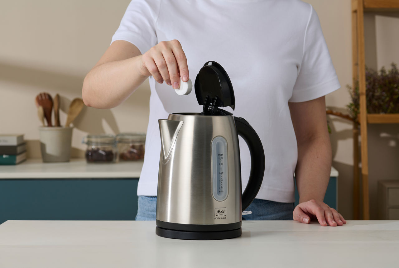 Person entkalkt Melitta Wasserkocher mit Swirl Anti Calc Tabs